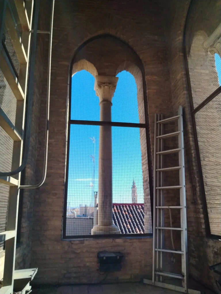 Detalle de un muro de piedra junto a una ventana en un templo antiguo analizado para ventilación y seguridad.
